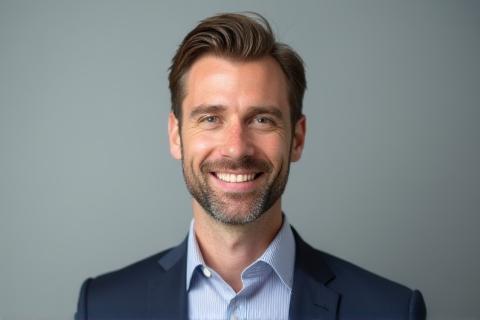 Headshot profissional de um empresário sorrindo em estúdio.